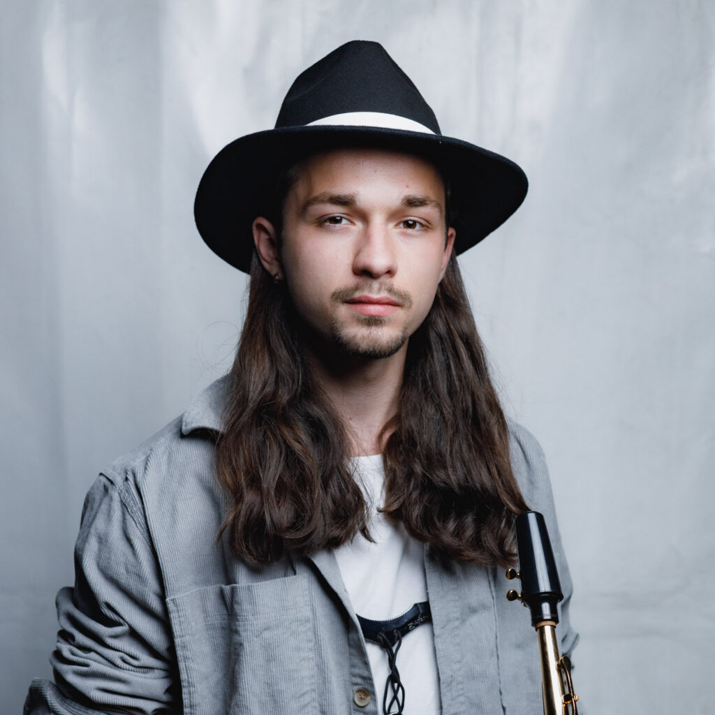 Jason, Saxophonist der HOUSE PLAYER, Porträt mit Saxophon und Hut